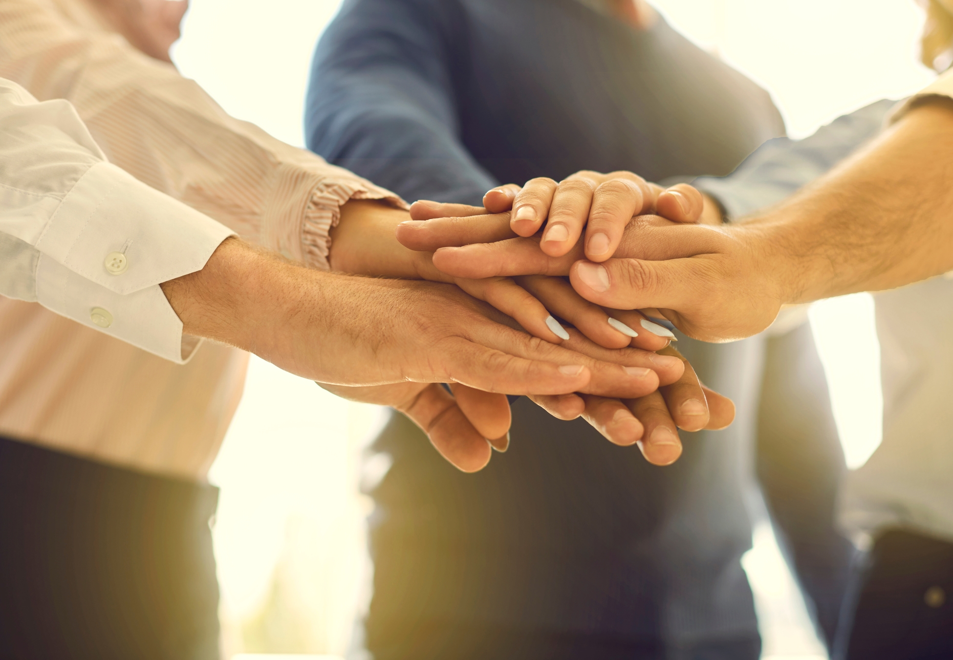 A team joining hands.